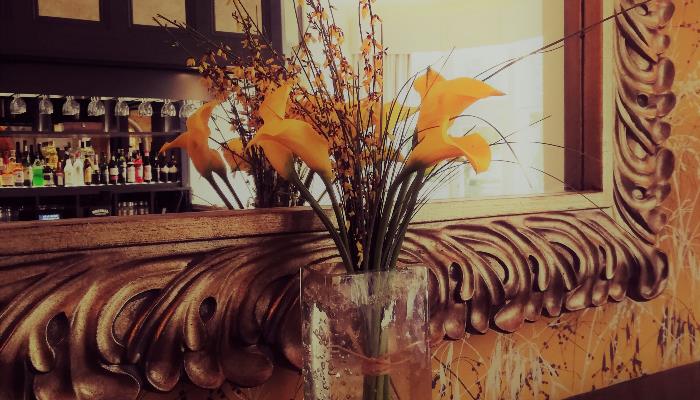 Yellow flowers in a glass vase on the fire place mantel