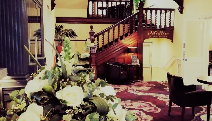 Wooden stairwell, wooden pillars, white flowers & deep red patterned carpets