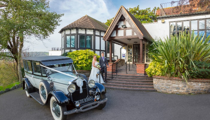 Wedding couple and car outside the front of the hotel