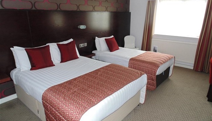 Lancashire Manor Hotel - Room 6 - Spacious room with a double bed and single bed. Wallpaper, curtains and bedding is red.